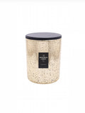 A speckled gold glass candle jar with a d charcoal lid and a black label reading 'Spitalfields Candle Co'.